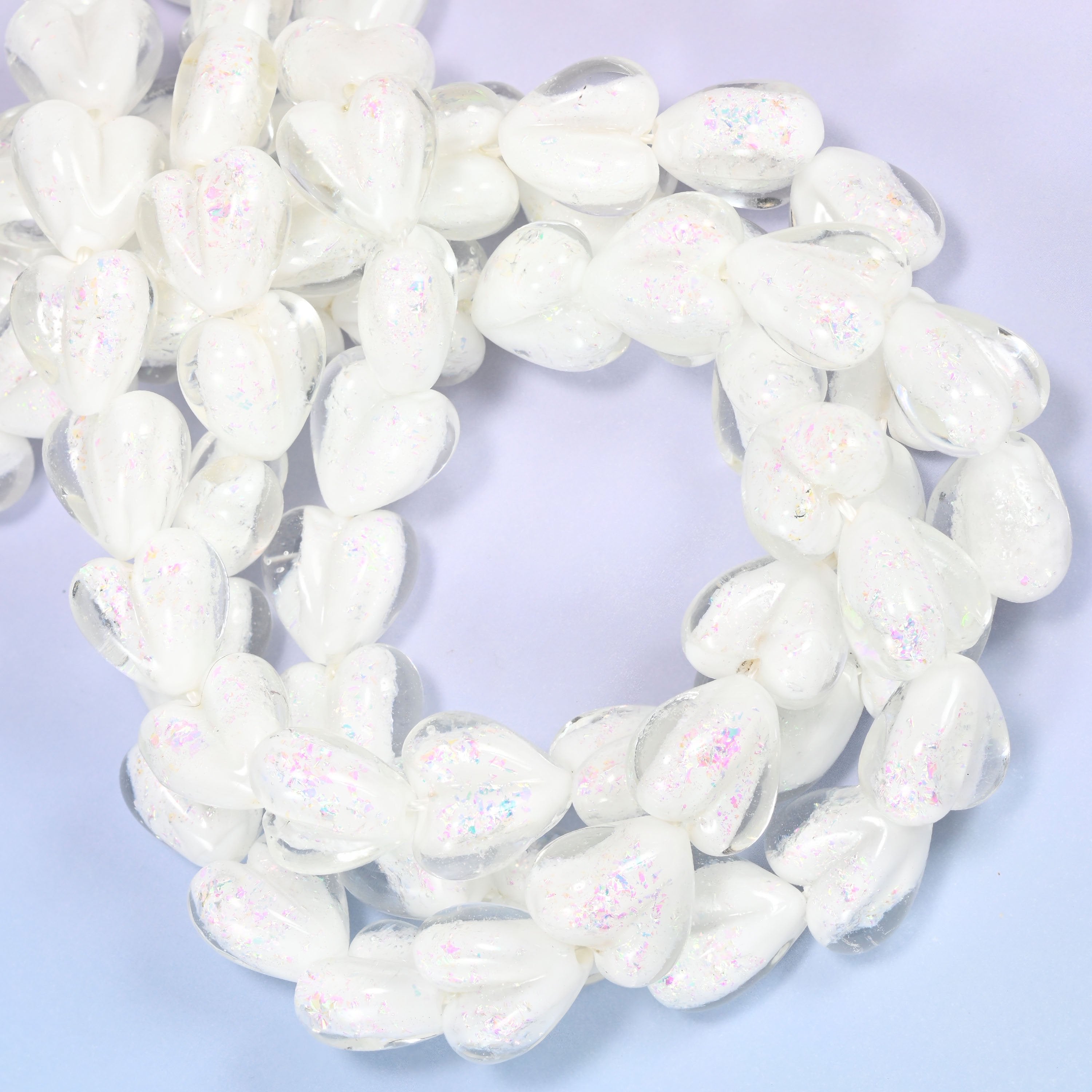 Iridescent White Heart glass beads, close view of the coiled strands in opaque white with a pearly sheen