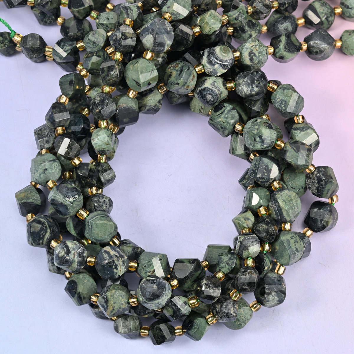 Kambaba Jasper faceted spiral twist beads, close view of the coiled strands showing dark green with mottled olive rings