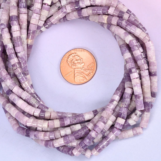 Lepidolite smooth heishi disc bead strands coiled around a US penny for size reference