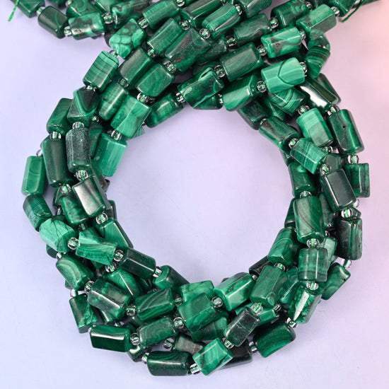 Malachite faceted tube beads, close view of the coiled strands showing banded green with silver spacers