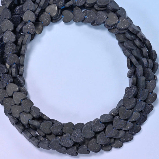 Matte Blue Sandstone flat heart beads, close view of the coiled strands in near-black navy with a matte finish
