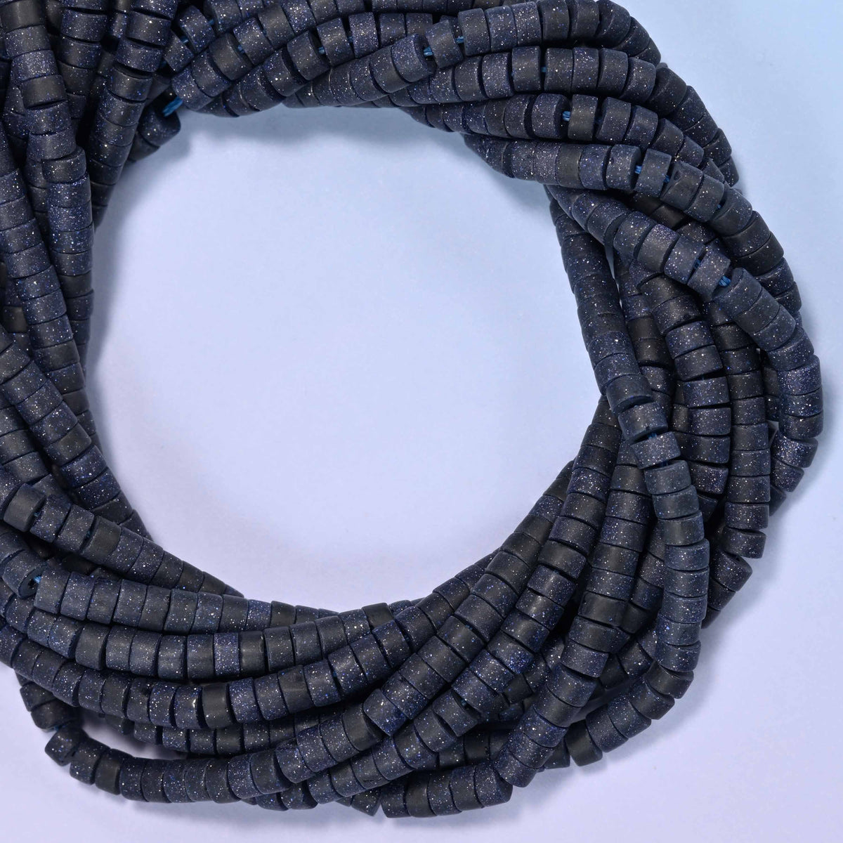 Matte Blue Sandstone heishi disc beads, close view of the coiled strands showing the deep navy color with a soft matte finish