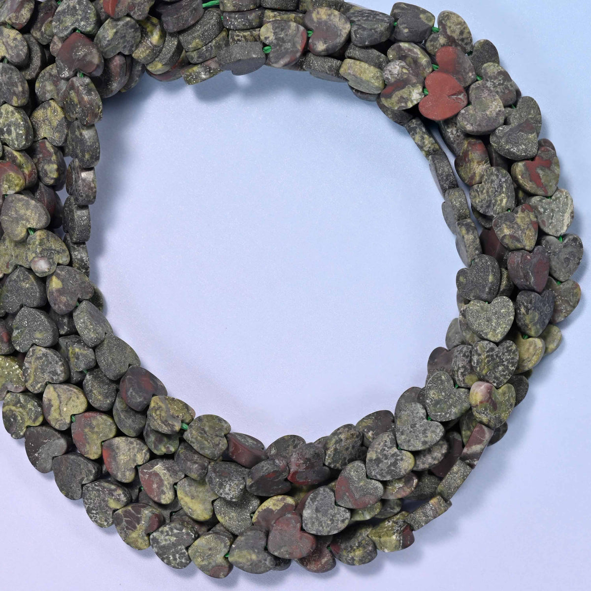 Matte Dragon Bloodstone flat heart beads, close view of the coiled strands in mottled dark green with red-brown markings