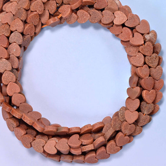 Matte Gold Sandstone flat heart beads, close view of the coiled strands in coppery brown with a matte finish
