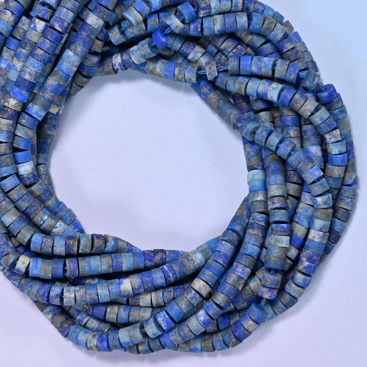 Matte Lapis Lazuli heishi disc beads, close view of the coiled strands showing deep blue with grey and gold flecks