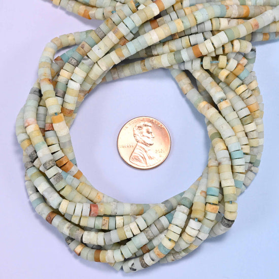Matte Multicolor Amazonite heishi disc bead strands coiled around a US penny for size reference