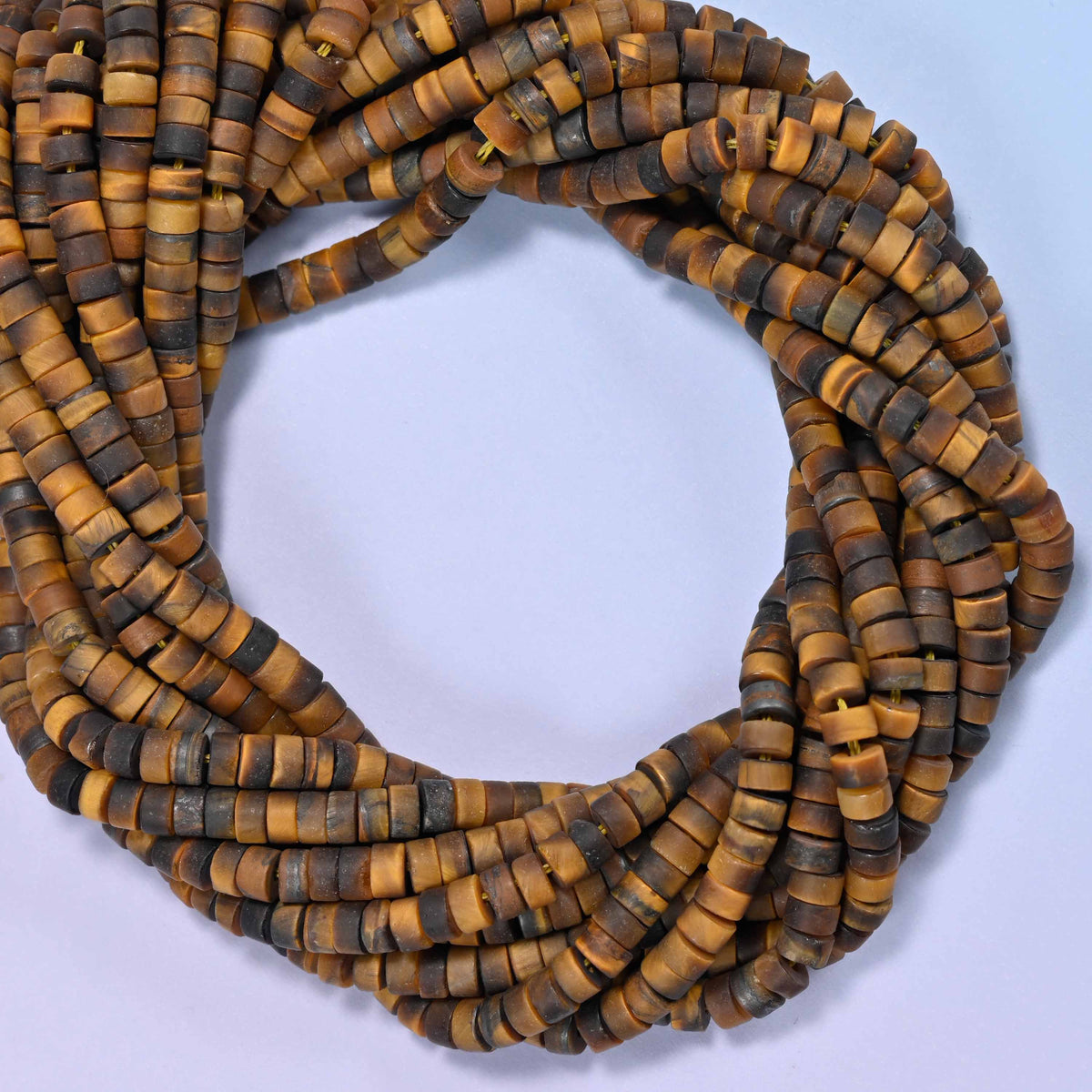 Matte Tiger Eye heishi disc beads, close view of the coiled strands showing golden brown bands with darker stripes