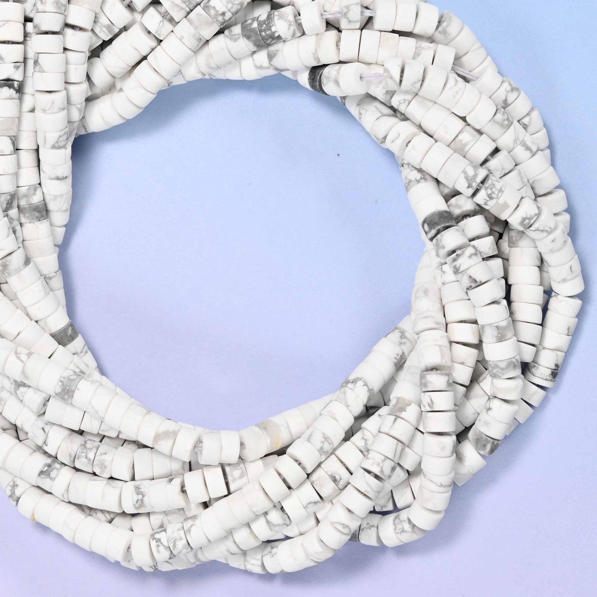 Matte White Howlite heishi disc beads, close view of the coiled strands showing chalky white with grey veining