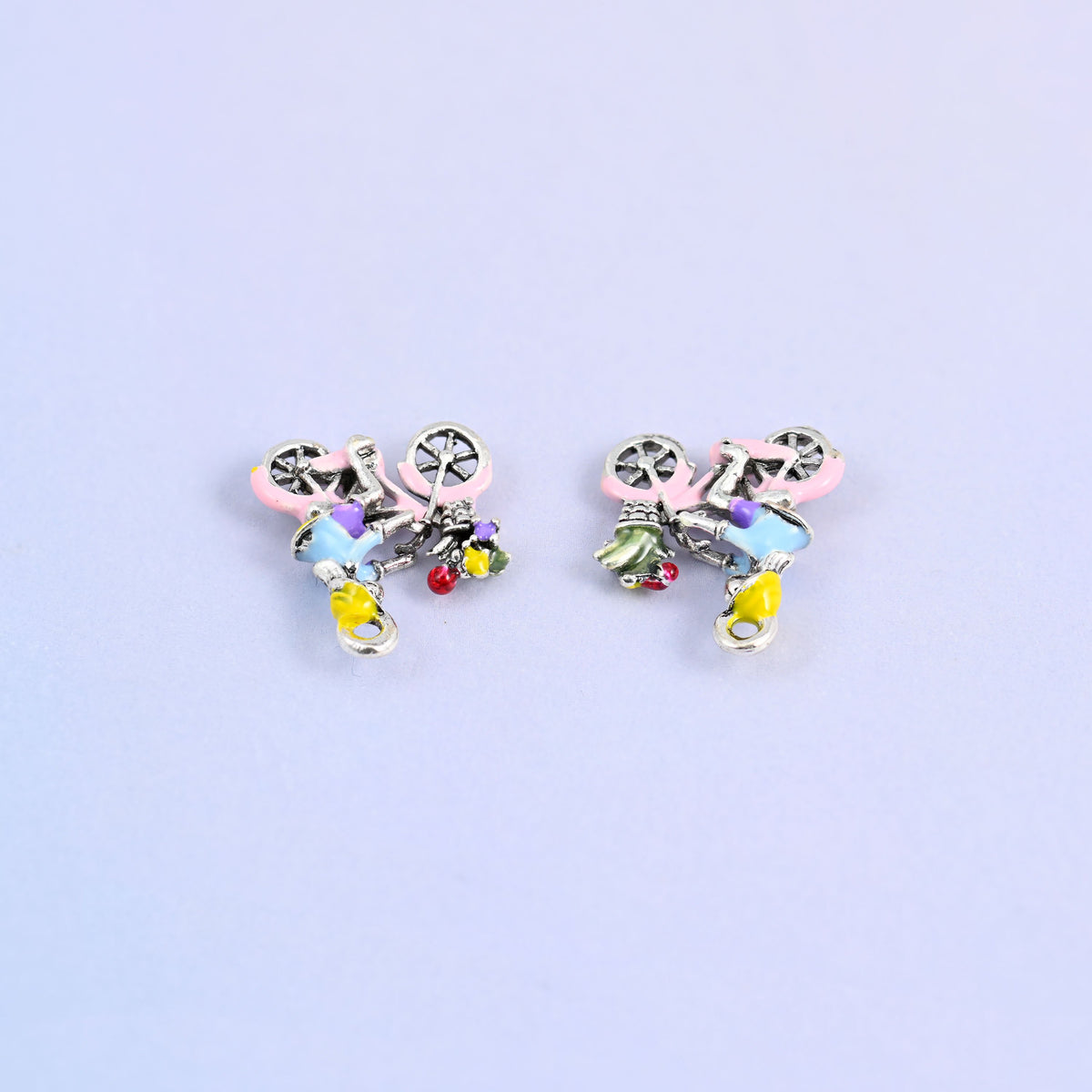 Two bicycle charms lying face down, showing the molded reverse.