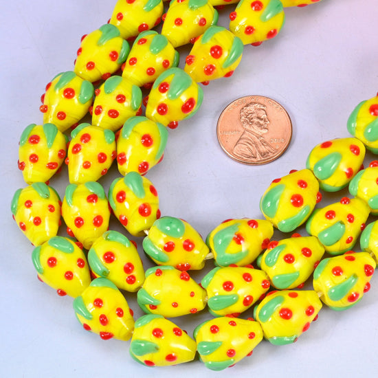 Strawberry shaped lampwork glass beads scattered with small red seed dots