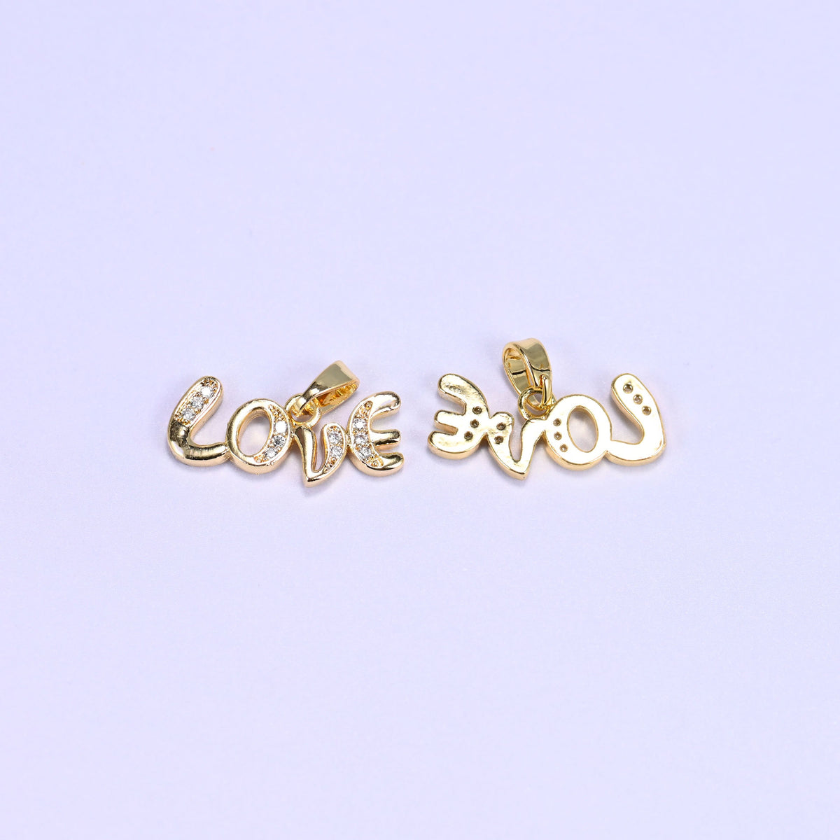 Gold Love letter zirconia charms shown front and back, one script pendant face up and the second flipped to reveal the reverse.