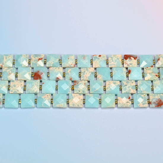 Several strands of dyed blue Shoushan stone faceted flat square beads laid in straight rows