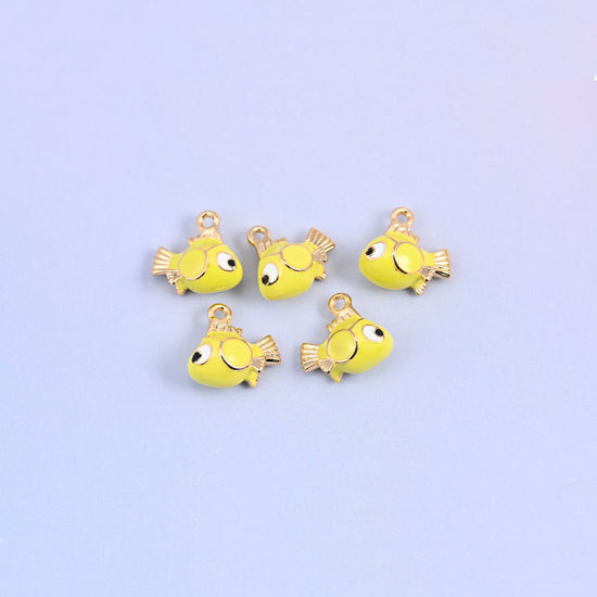 Five fish charms scattered together, yellow green enamel bodies with big cartoon eyes and gold plated fins.