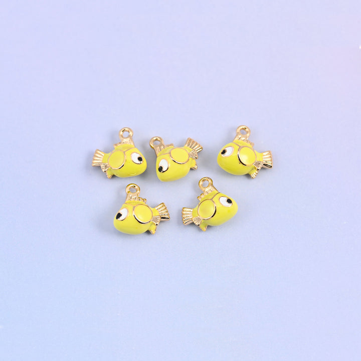 Five fish charms scattered together, yellow green enamel bodies with big cartoon eyes and gold plated fins.