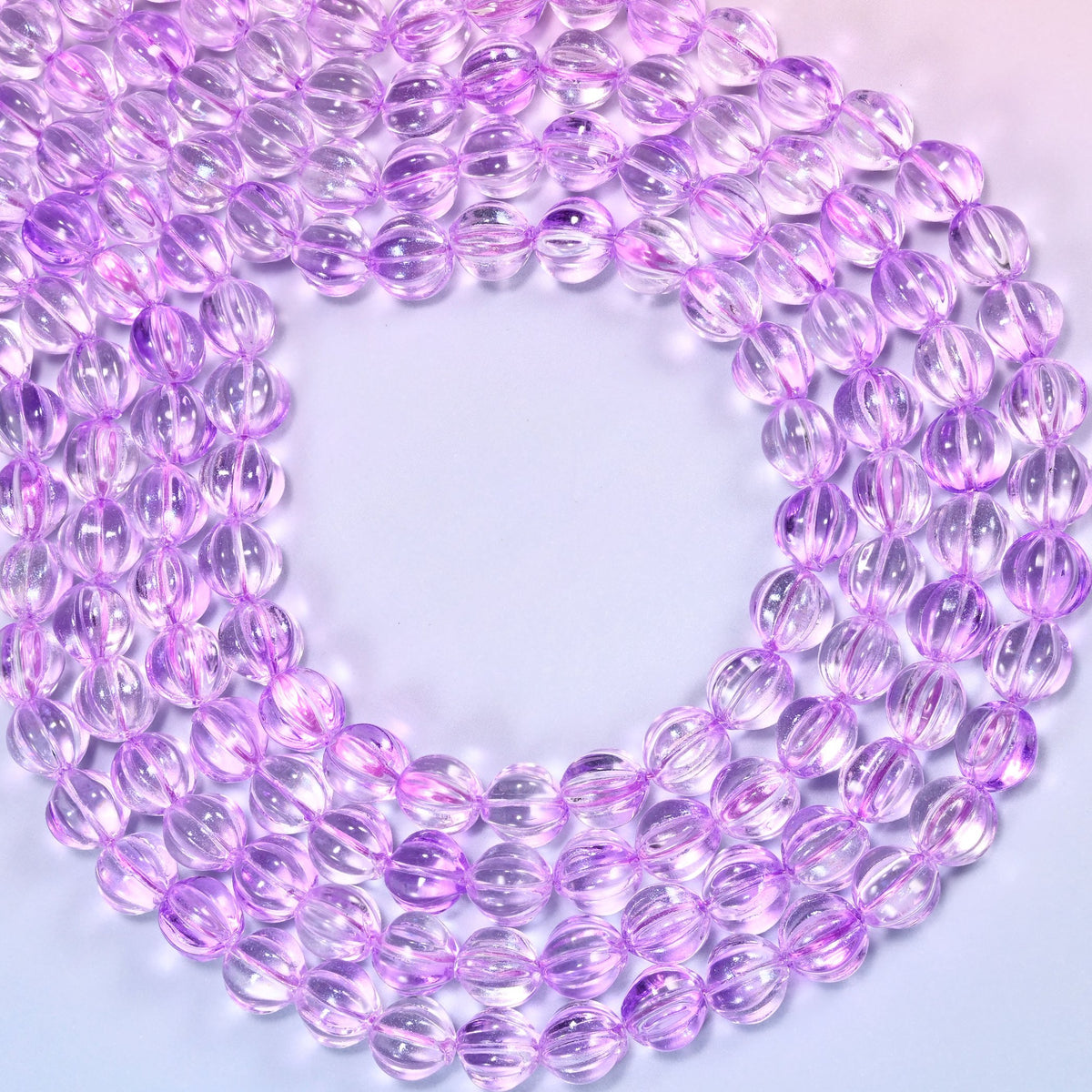 Clear purple pumpkin glass beads coiled into a wide open ring, the fluted grooves catching the light.