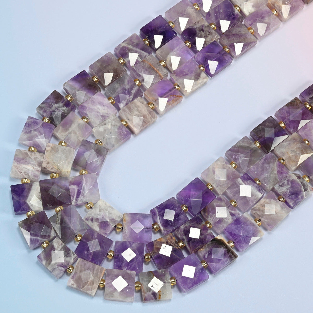 Natural amethyst faceted flat square beads in several strands curved into a wide U, deep purple, lavender and clear stone