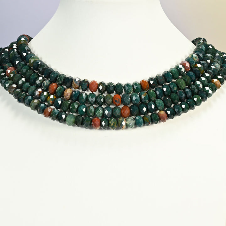 Oriental jasper faceted rondelle strands arranged as a layered collar on a white display bust, dark green and red beads