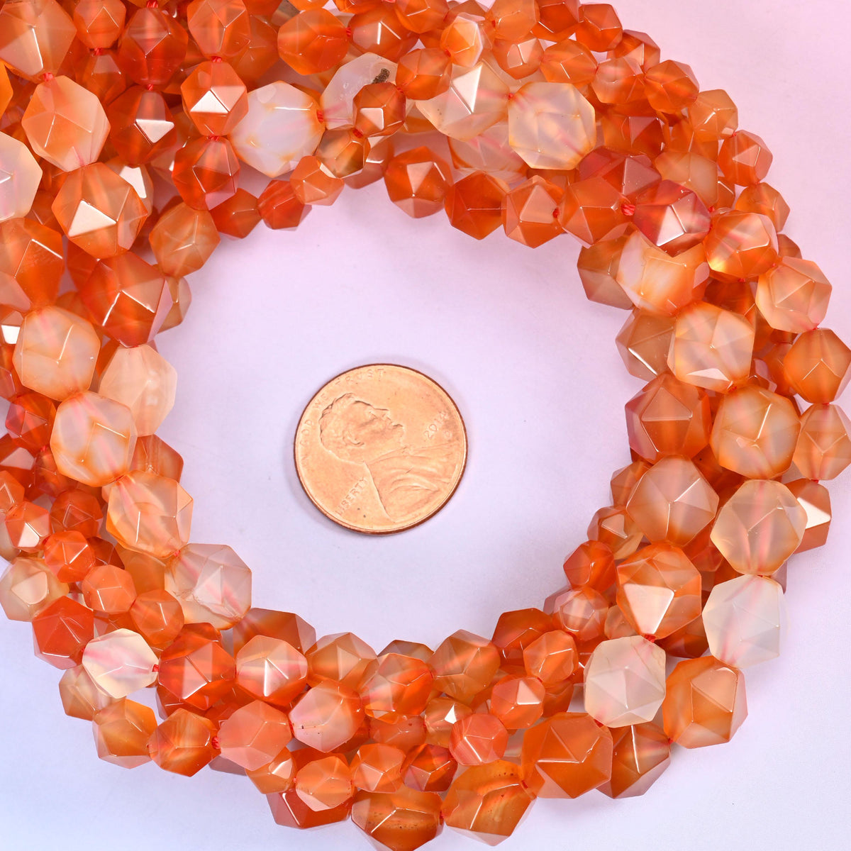 Orange Agate beads coiled around a US penny, hole size approximately 1.0mm, deep orange with cloudy cream zones