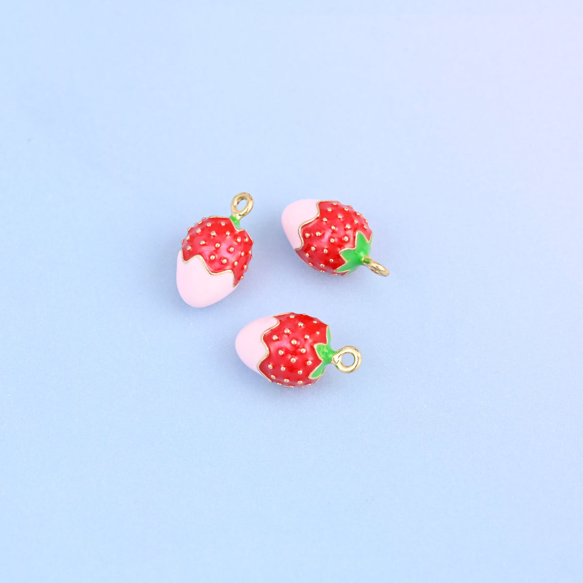Three strawberry charms dipped in light pink enamel, enamel over 18K gold plated brass.