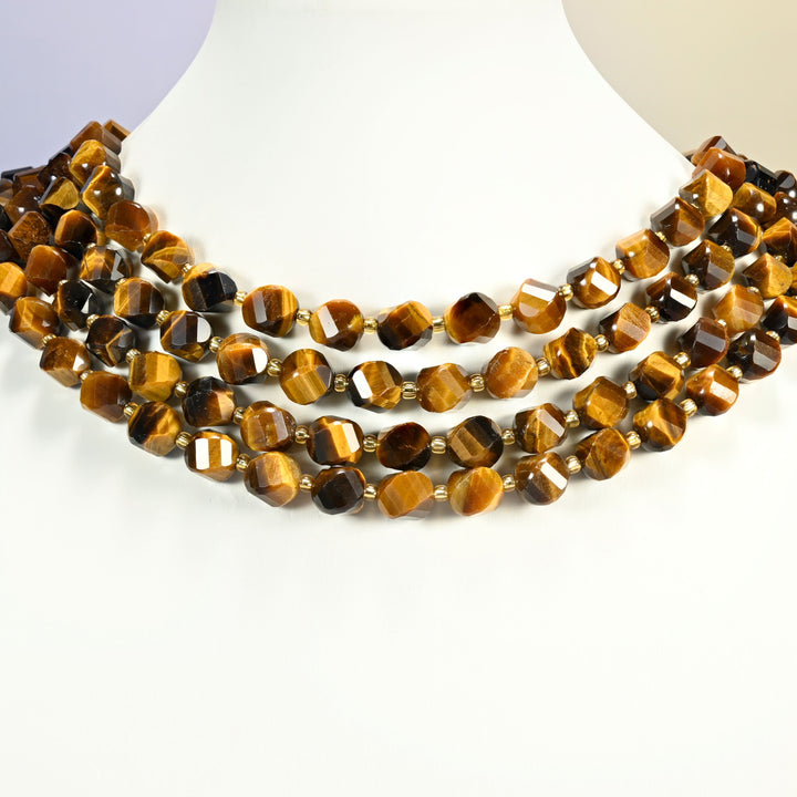 A+ tiger eye faceted spiral twist strands arranged as a layered collar on a white display bust, golden brown beads across the neck