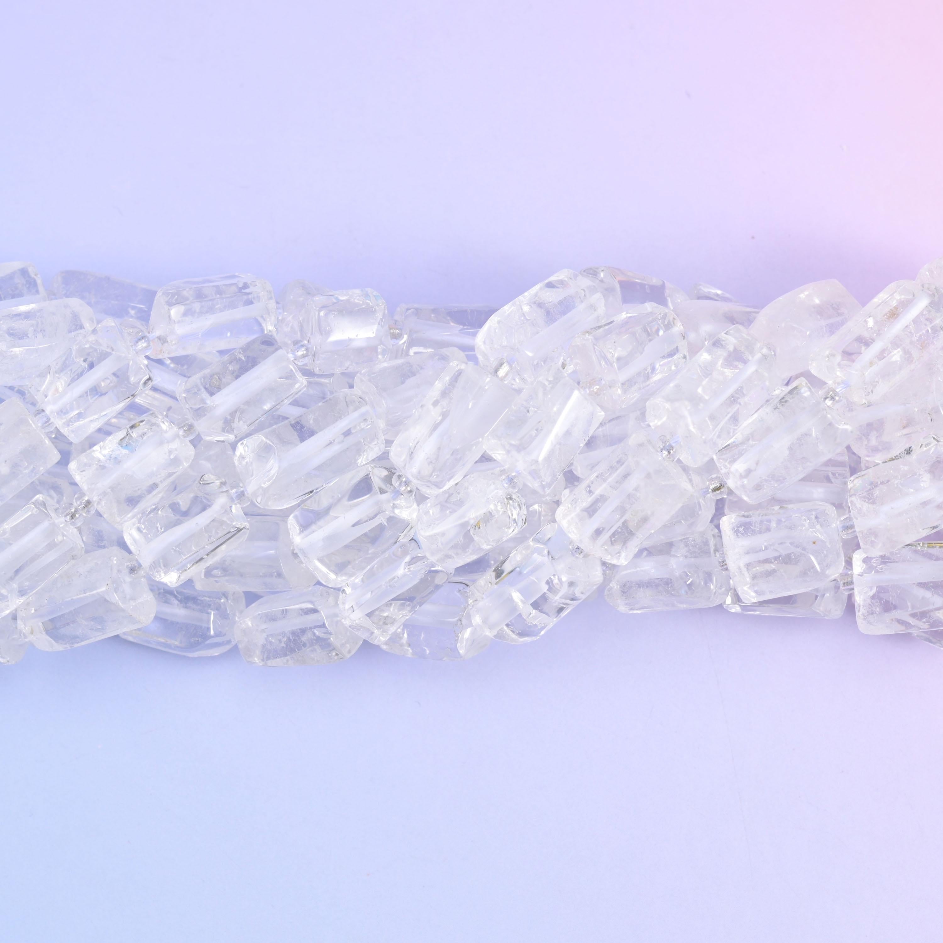 Strands lying in a shallow S, frosted fracture lines catching light inside otherwise glassy beads