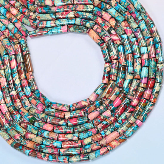 Dyed sea sediment jasper tube beads 13x4mm curved into an open loop, showing the turquoise and pink mix across whole strands