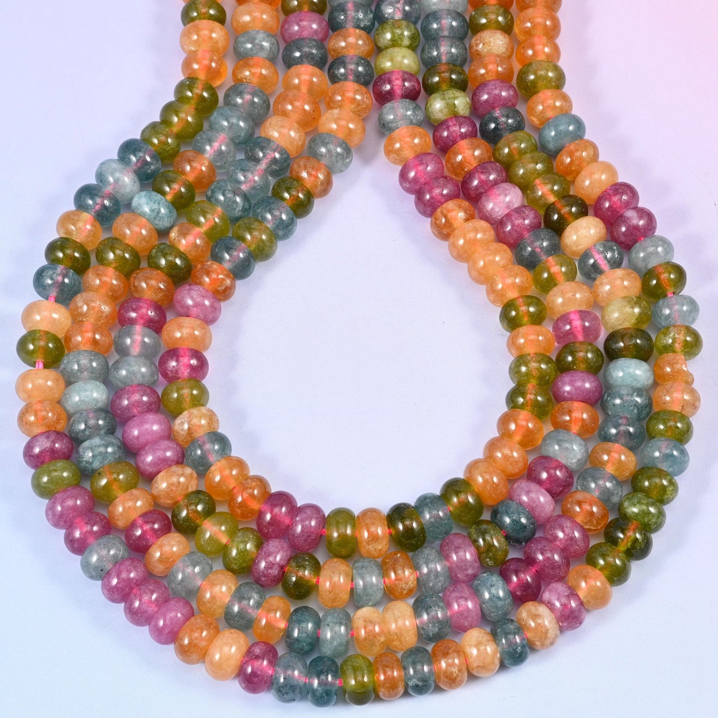 A cheerful four-colour mix — orange, blue, green and pink jade rondelles, each one smoothed and polished so the strand reads as clean blocks of colour rather than a busy jumble