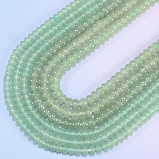 Green Aventurine gemstone rondelle beads curving in a wide U across the frame, 4x6mm and 5x8mm strands together