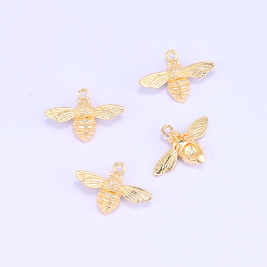 Small gold charms bee, five 18K gold plated charms scattered to show the shape and polished finish