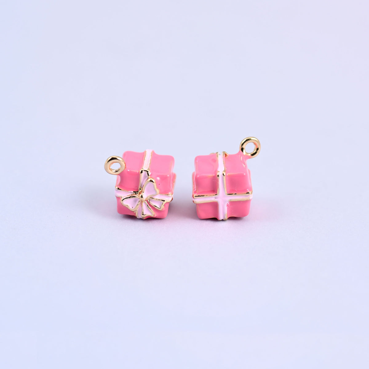 Two pink gift box charms with light pink enamel ribbon and bow.