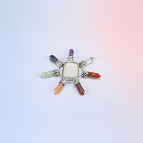 Crystal energy generator with a clear quartz center pyramid and seven chakra crystal points in a silver-tone frame