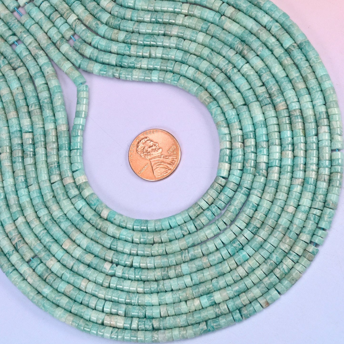 Soft seafoam blue drifting into teal, marbled with fine white veining and polished smooth across both faces of every disc.