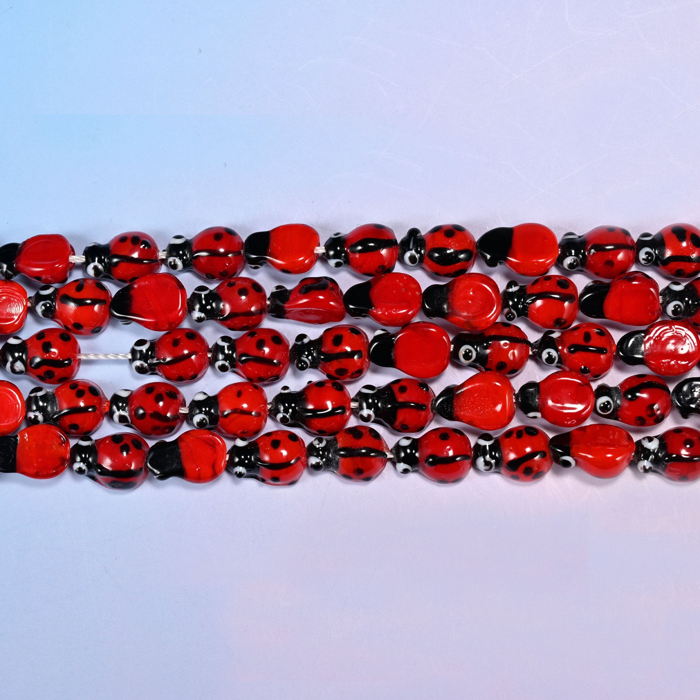 Ladybug glass beads with a fine dividing line down the wing cases.