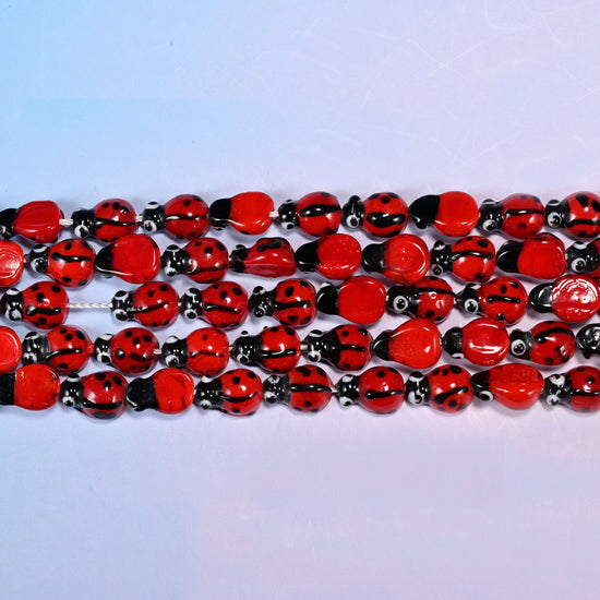 Ladybug glass beads with a fine dividing line down the wing cases.