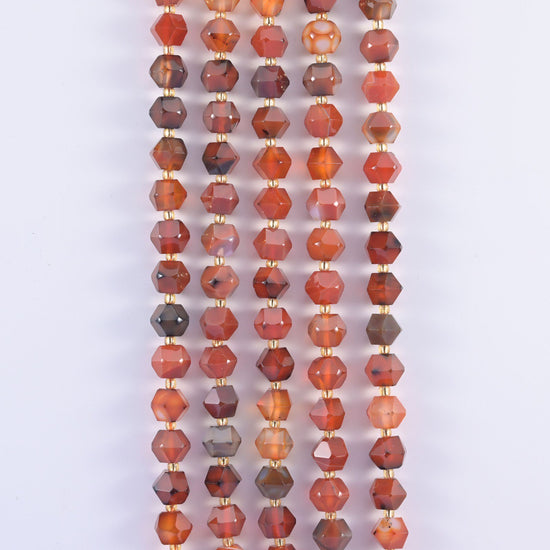 Faceted 8 sides diamond rhombus beads in dyed red strip agate in vertical rows, white banding crossing the orange.