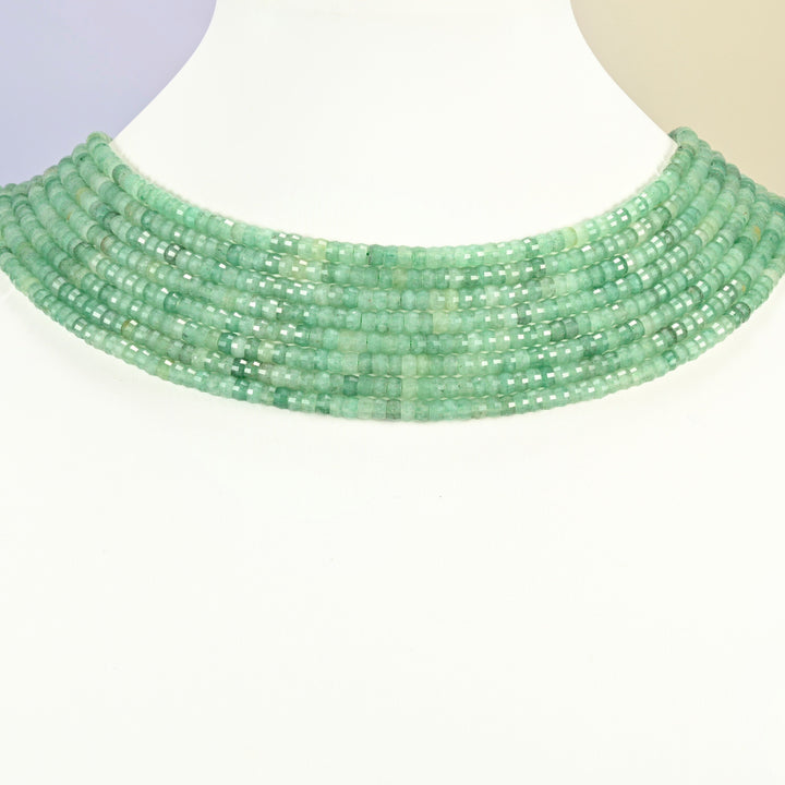 Green aventurine faceted heishi disc strands arranged as a layered collar on a white display bust, light green beads across the neck