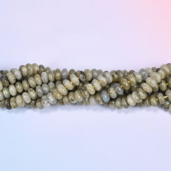 Close-up horizontal row of Grey Labradorite beads showing the grey stone pattern and subtle flash.