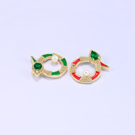 Green and red round snake charms angled together, showing how the enamel colour changes the look while the pearl and green stone stay the same.