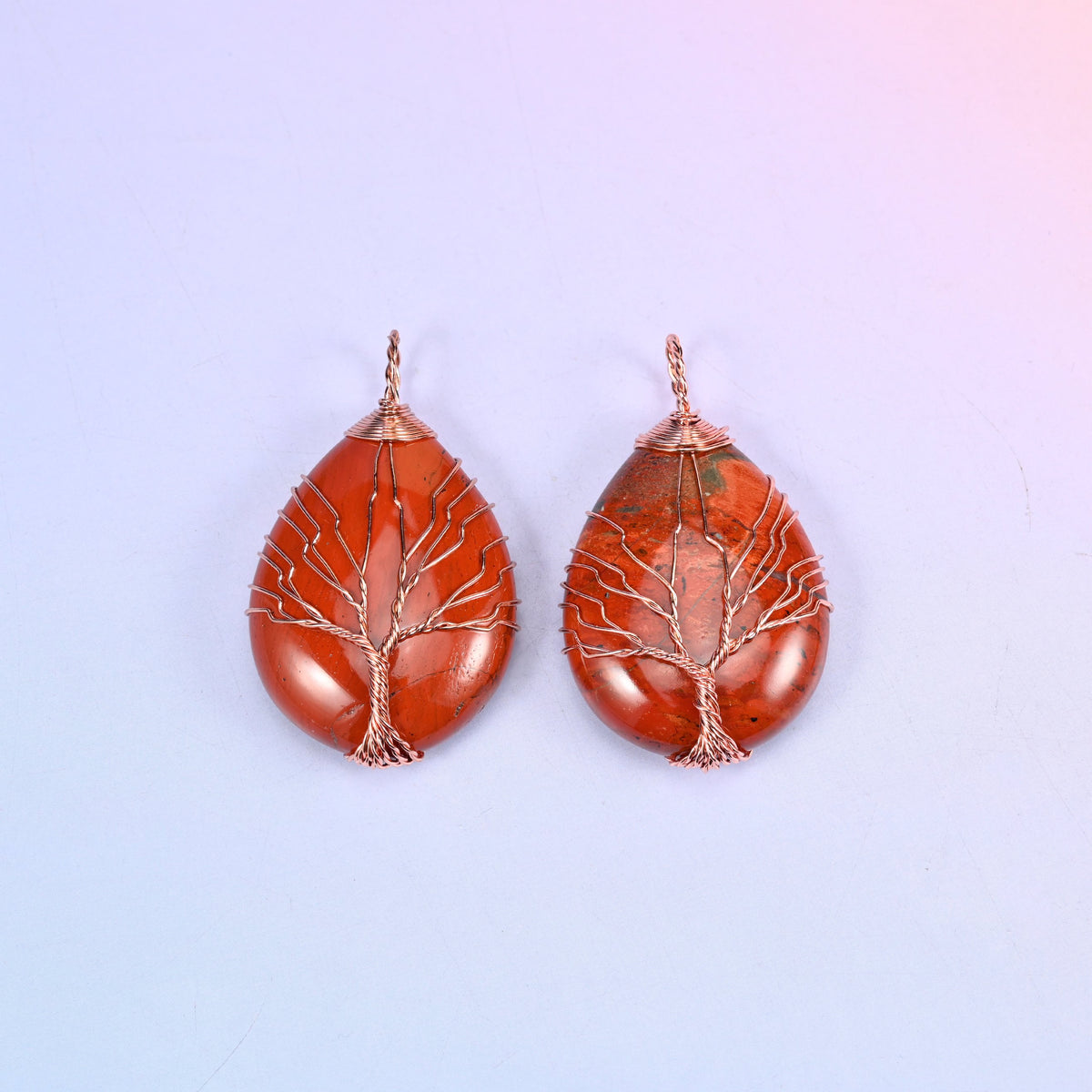 Teardrop Crystal Pendant with Copper Wired Tree in brick red jasper, two pieces showing the deep red stone behind fine copper branches.