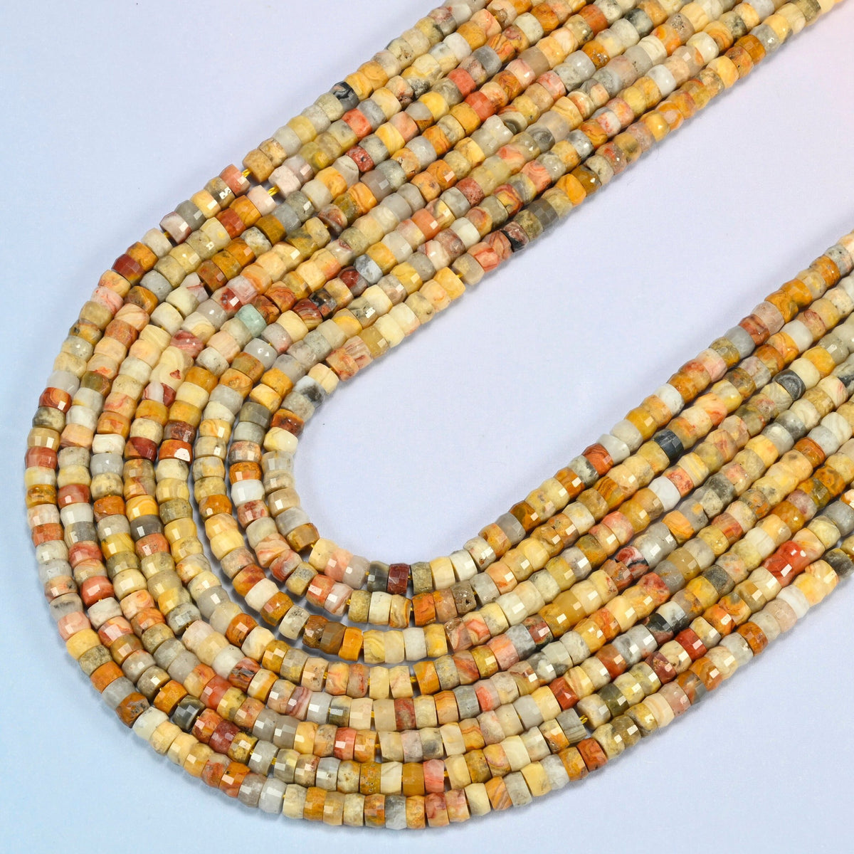 Crazy agate faceted heishi disc beads in several strands curved into a wide U, golden yellow, tan and brick red stone