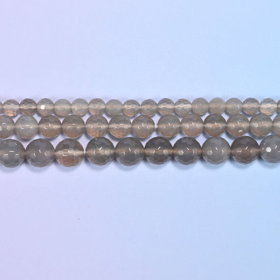 Full 15-inch strand of gray agate round beads laid out for jewelry making.