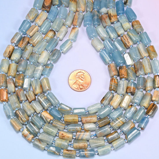 Blue calcite faceted tube beads shaped into a teardrop with a US penny inside the opening.