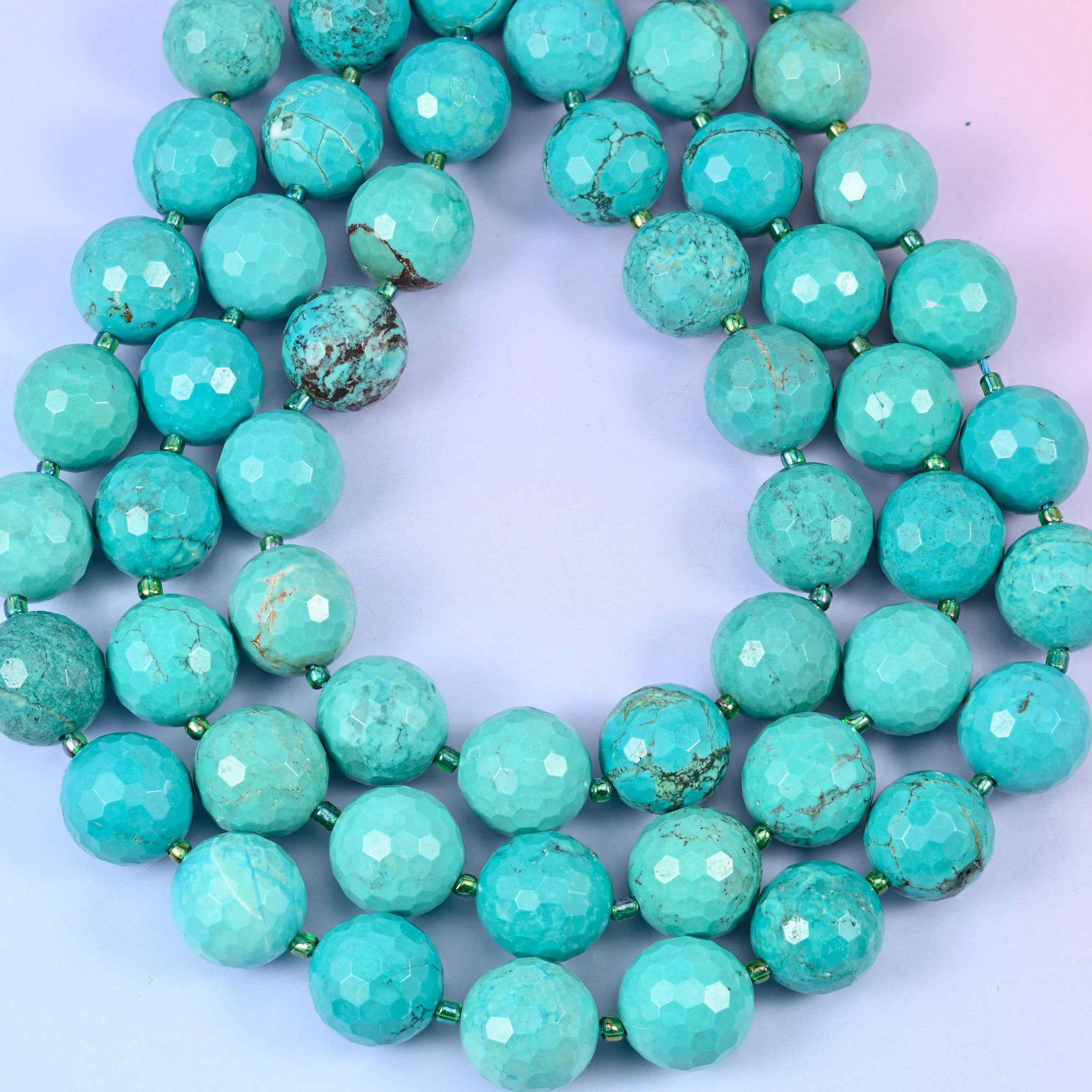 Big sea green to turquoise blue rounds webbed with fine brown and charcoal matrix, cut with dozens of shallow facets that dull the surface to a soft chalky sheen.