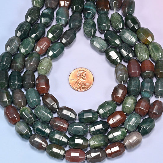 Wide circular coil of Indian Agate faceted barrel bead strands on a light lavender background with a penny in the center for size comparison.