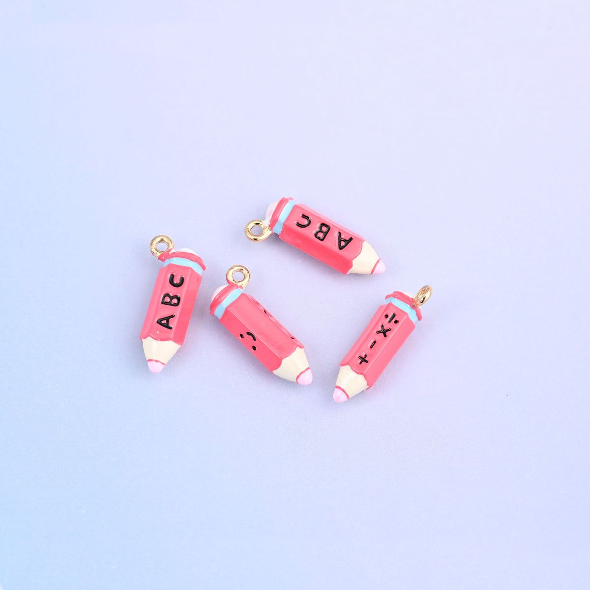 Four pink pencil charms with white tips, lettered ABC.