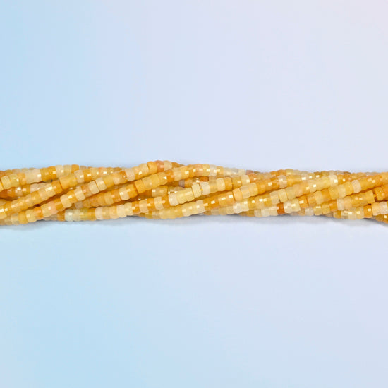 Strands of Gold Silk Jade faceted heishi disc beads twisted together in a horizontal row