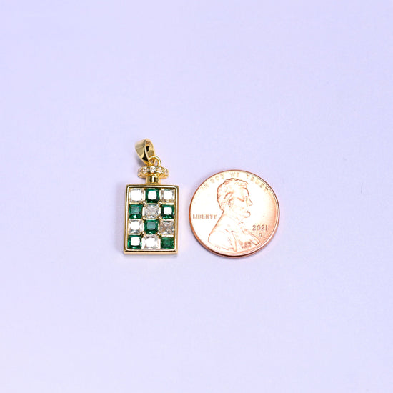 Scale shot of the perfume bottle zirconia charm, the green checkerboard pendant next to a US penny and a little taller than the coin.