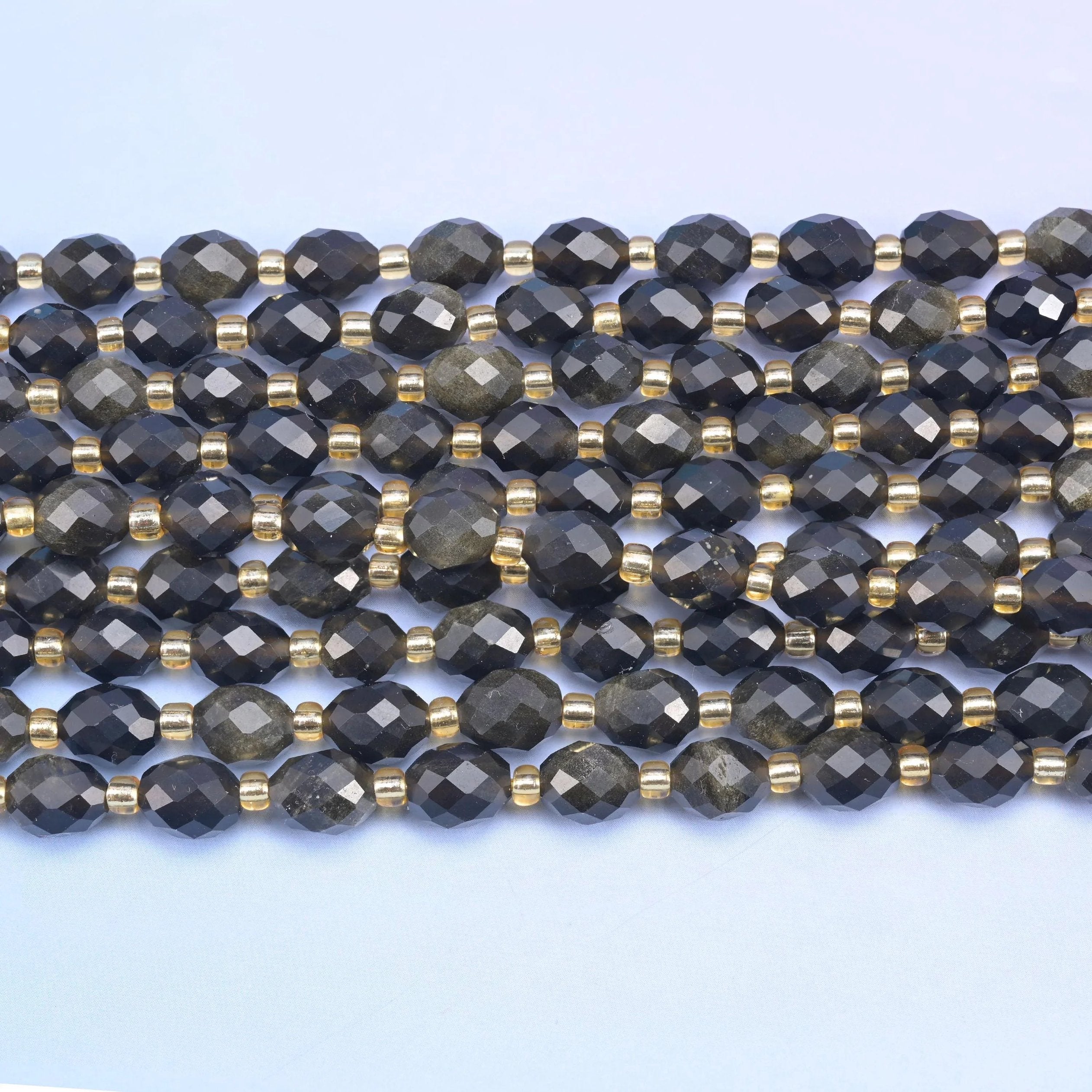 Faceted rice barrel cut gold obsidian beads