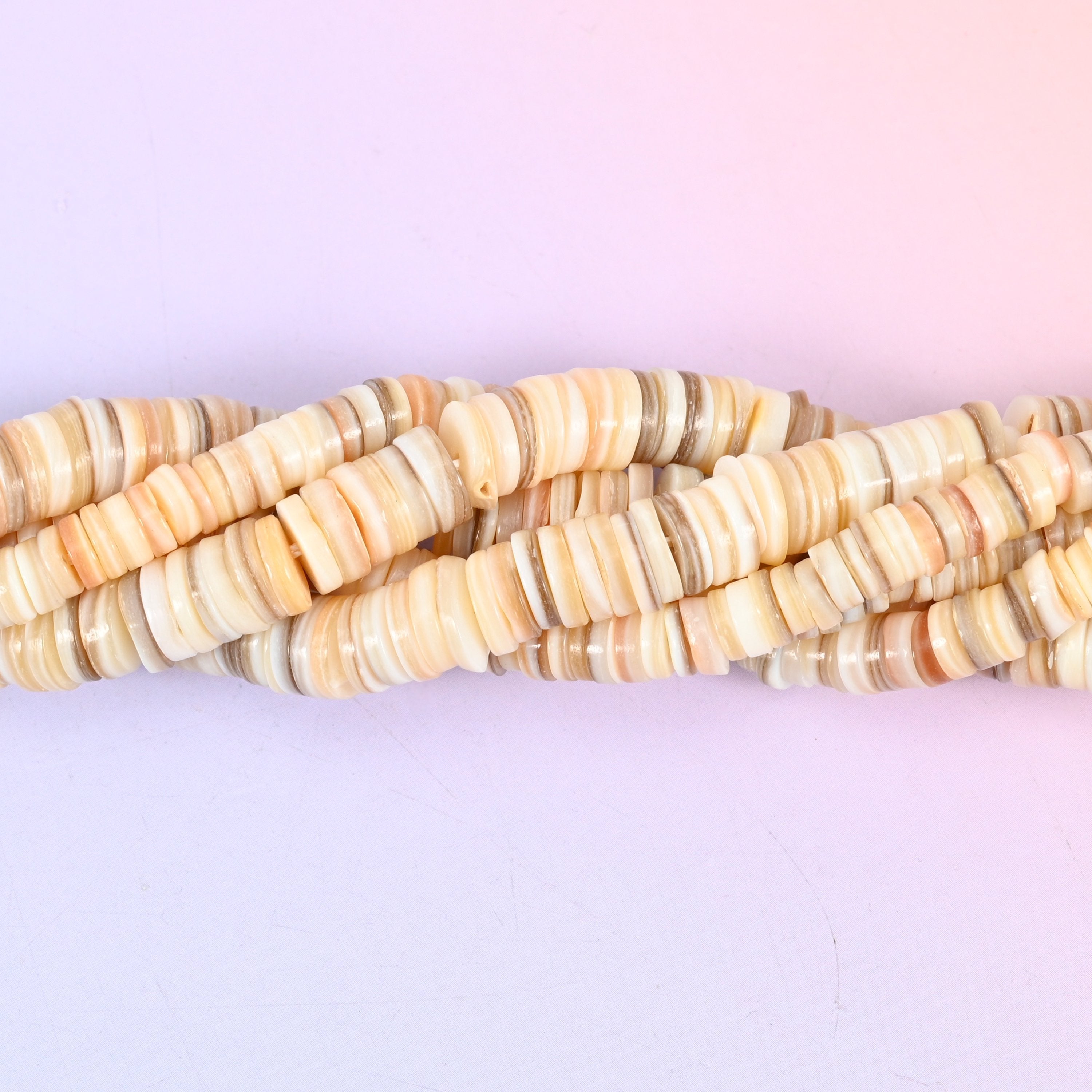 Natural Shell Round Disc Spacer Beads, thin heishi-style discs in warm cream, sand, taupe and blush, each carrying the shell's own fine growth lines.