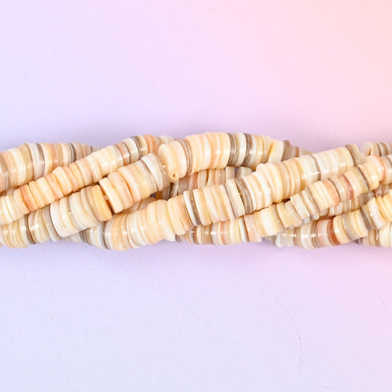 Natural Shell Round Disc Spacer Beads, thin heishi-style discs in warm cream, sand, taupe and blush, each carrying the shell's own fine growth lines.